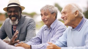 Three older gentlemen laughing at something being said