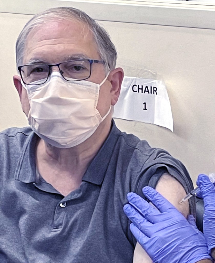 Dr. Tabak receiving a vaccination in his shoulder
