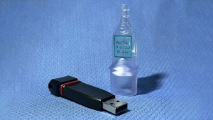 Small plastic device next to a thumbdrive