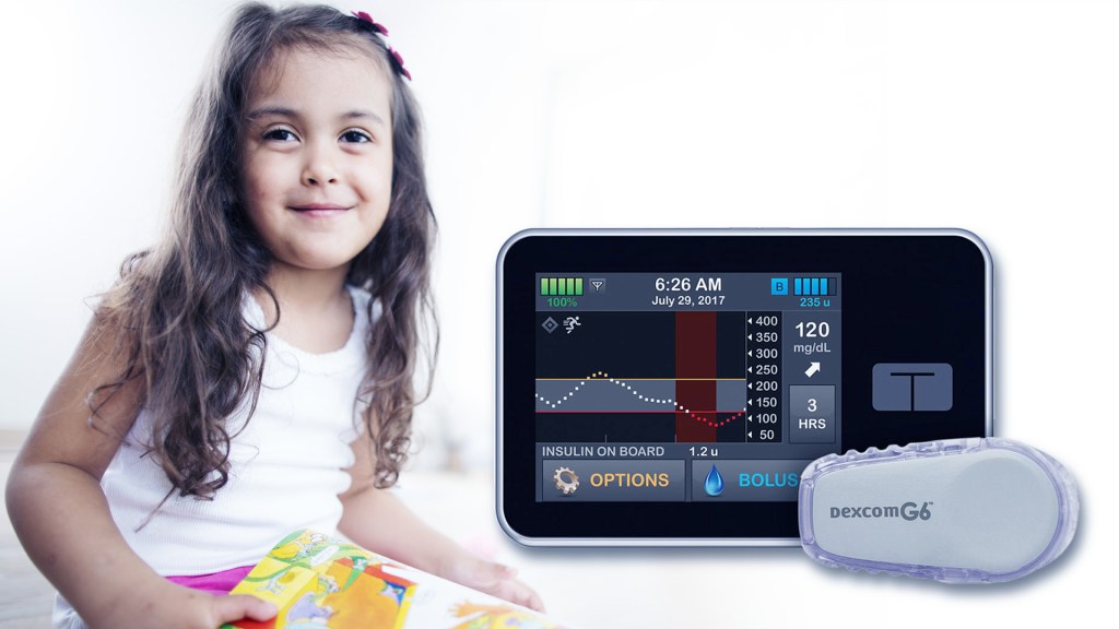 Smiling young girl with a photo of an insulin pump
